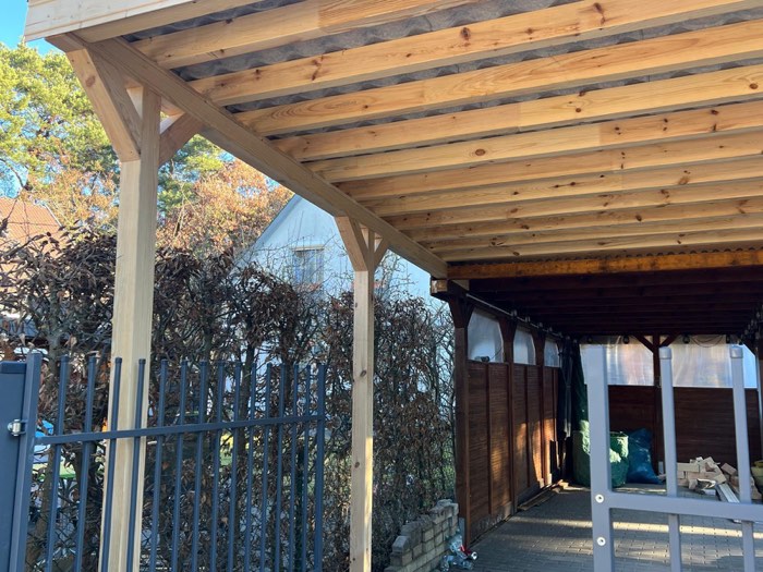 Carport din lemn cu structură aparentă și grinzi vizibile